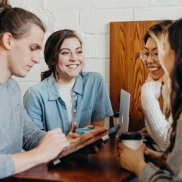 Four young people socialising at a cafe